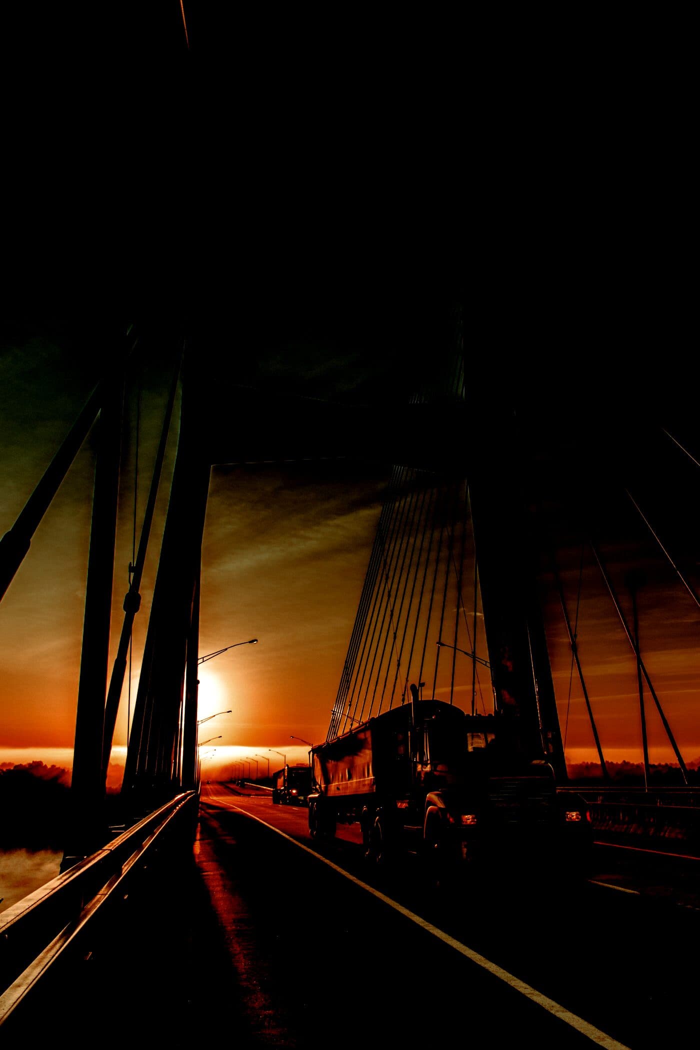 Semi truck crossing a bridge at dawn