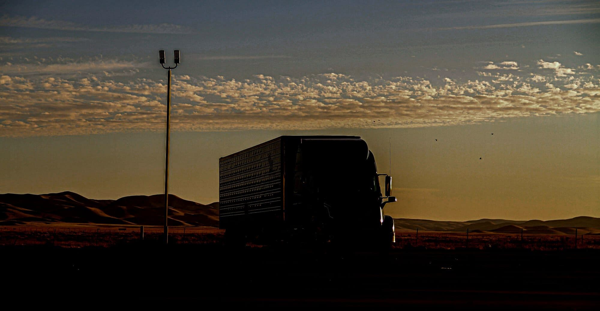 Semi truck running a mountain highway at dusk